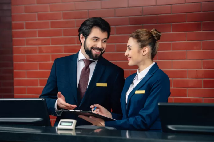 smiling,hotel,receptionists,working,together,at,counter