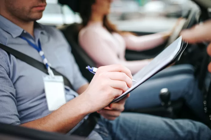 male,auto,instructor,takes,exam,in,young,woman.,close,up